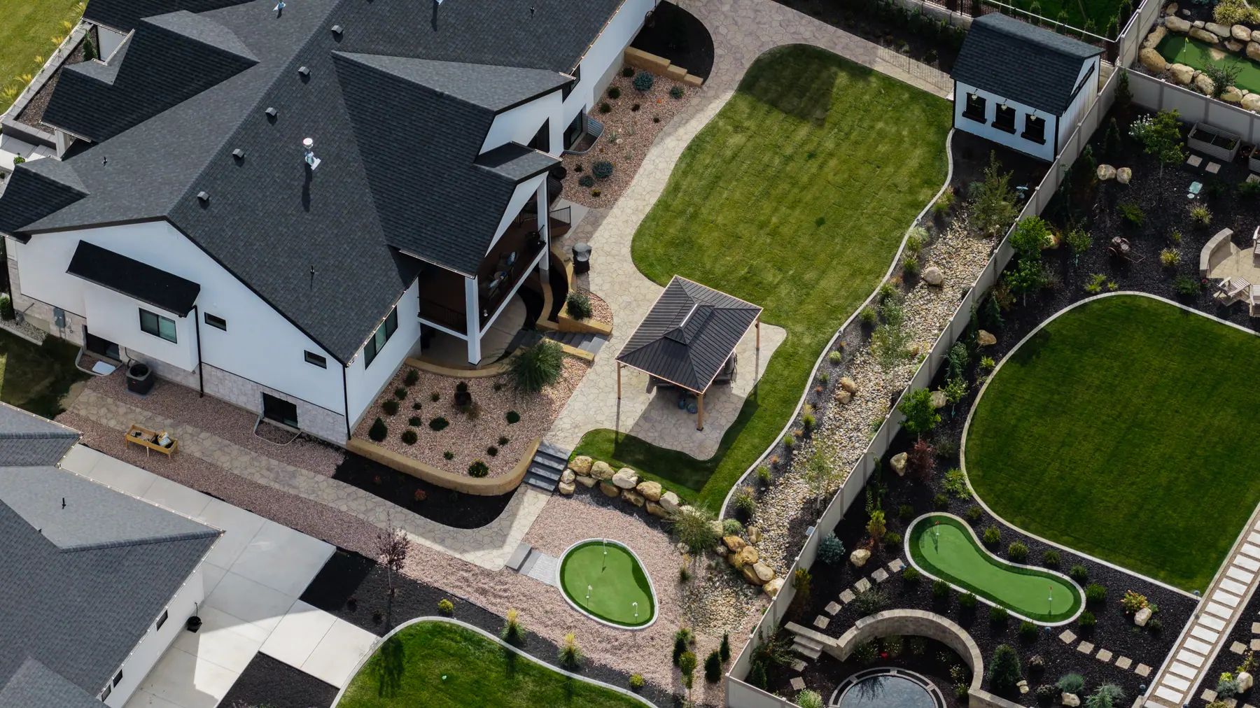 Backyard pavilion and putting green by J&H Landscaping in Utah County