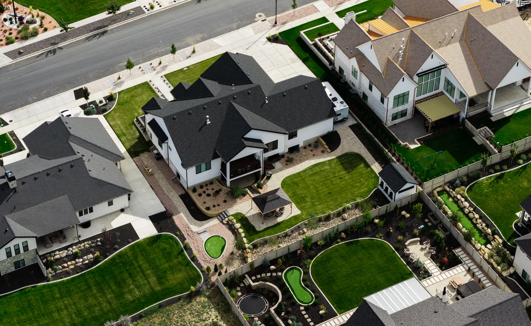 Backyard with putting greens by J&H Landscaping in Utah County