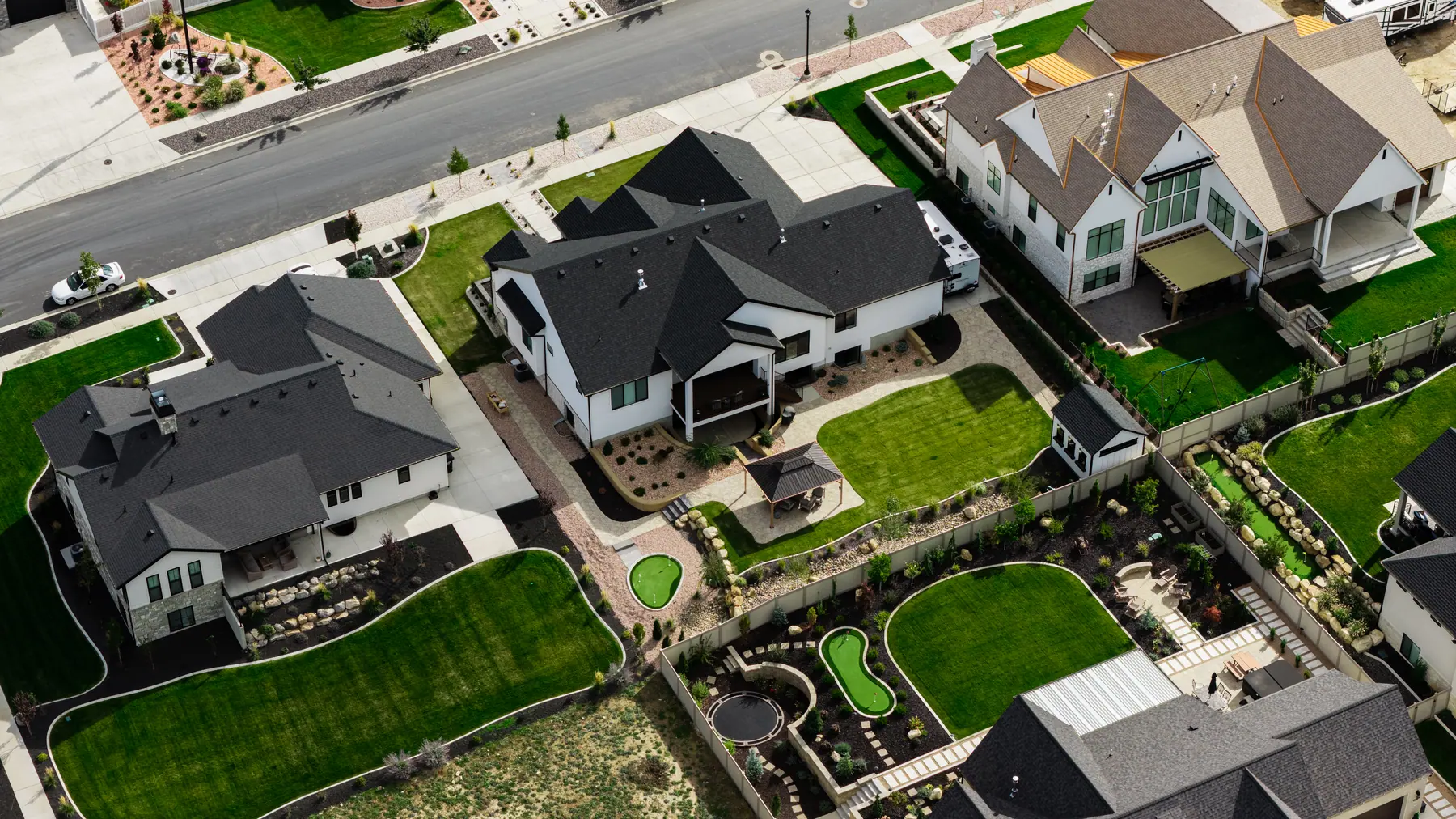 Backyard pavilion and putting greens by J&H Landscaping in Utah County