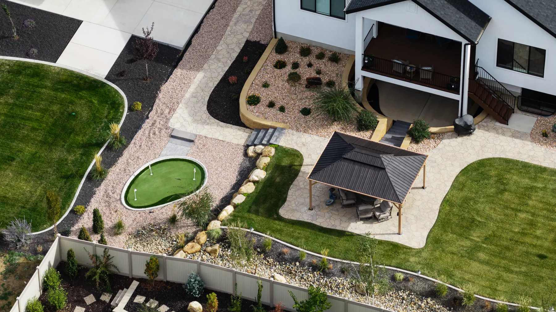 Pavilion, rock beds and putting green by J&H Landscaping in Utah County