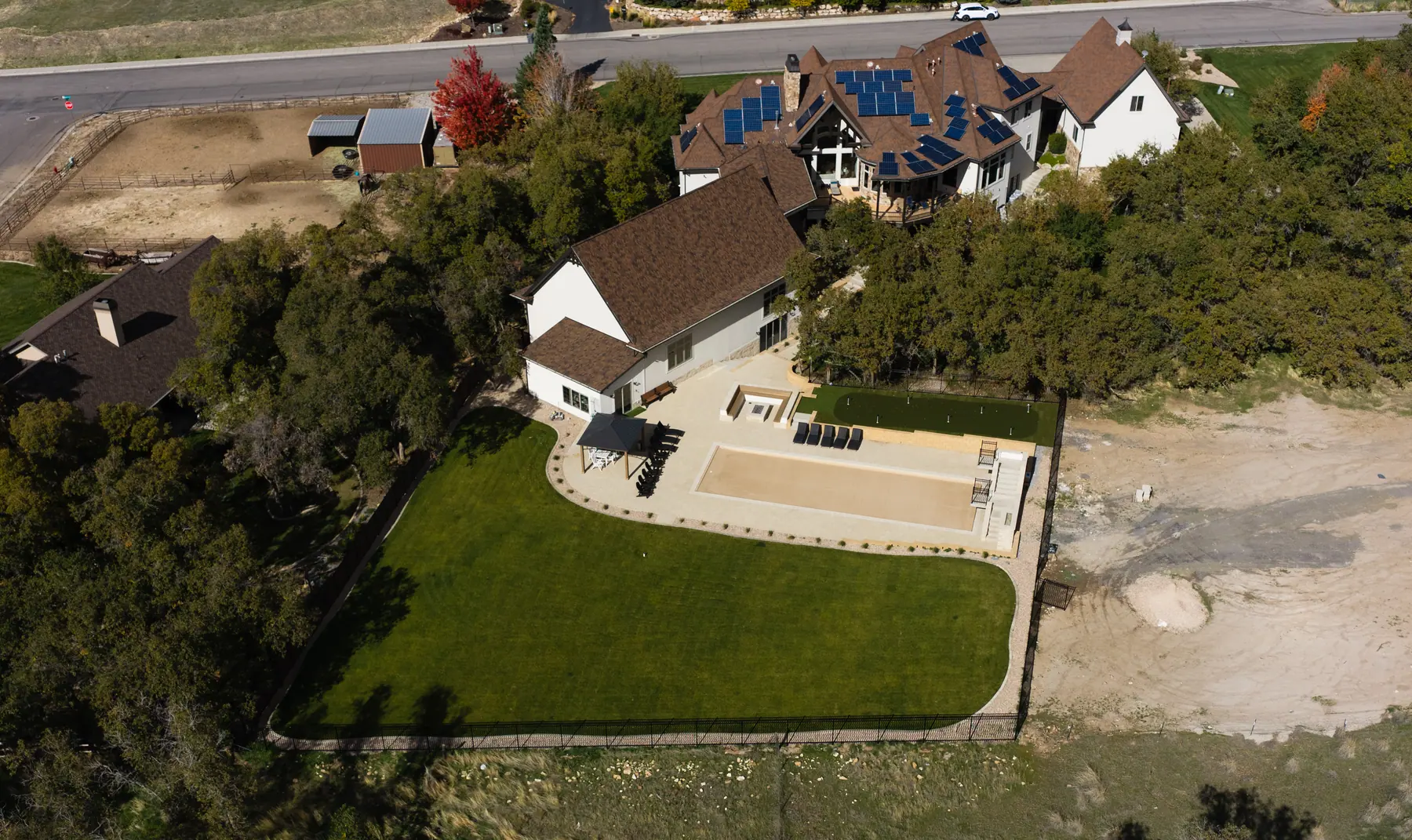 Big lawn and patio on a wooded lot by J&H Landscaping in Utah County