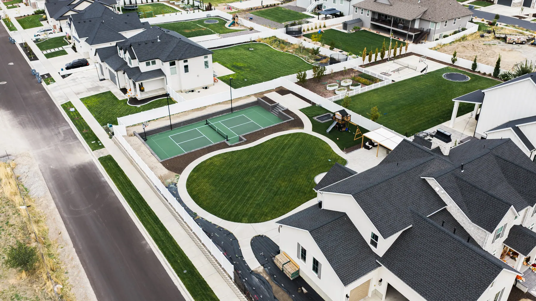 Pickleball court and curved lawn by J&H Landscaping in Mapleton