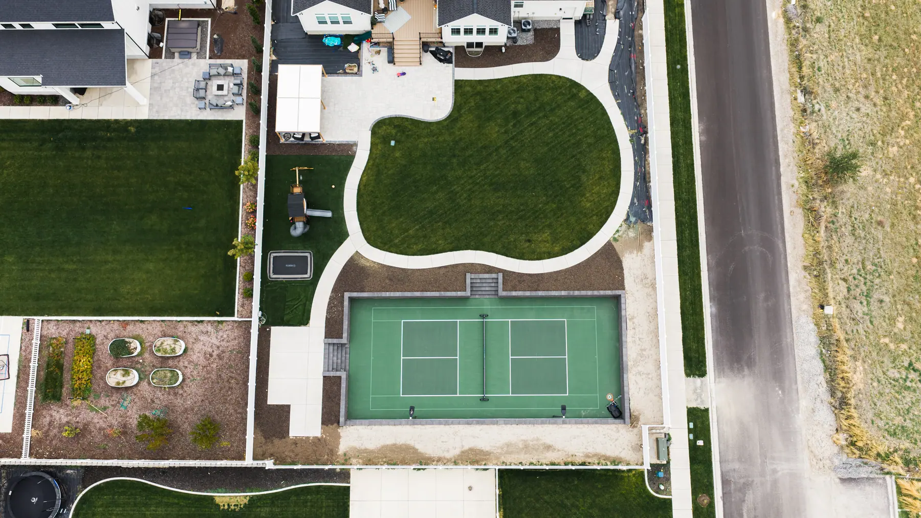 Curved lawn and court by J&H Landscaping in Mapleton