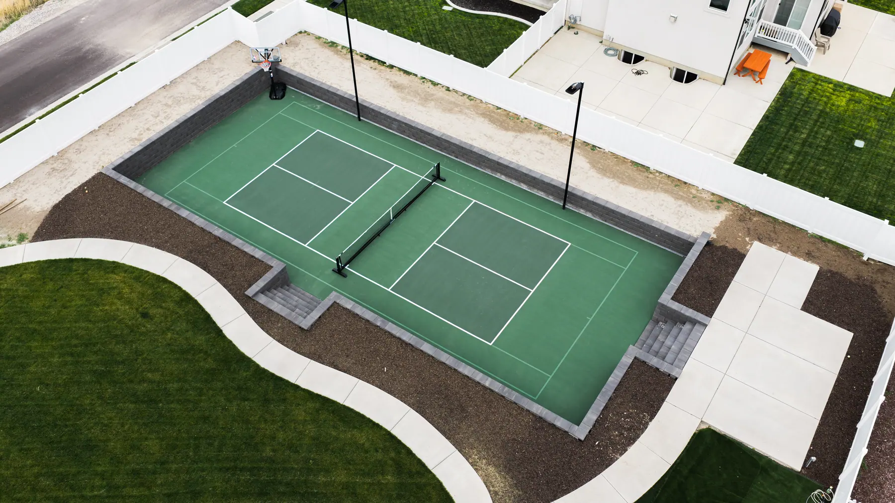 Pickleball court with lights by J&H Landscaping in Mapleton
