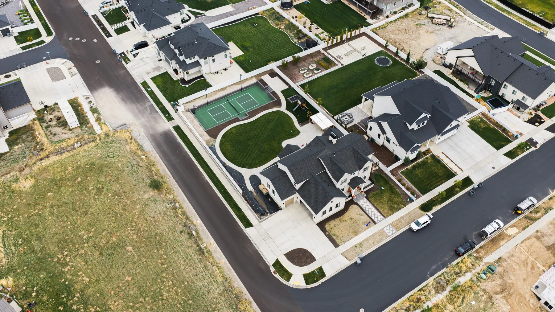Corner lot with a backyard court by J&H Landscaping in Mapleton