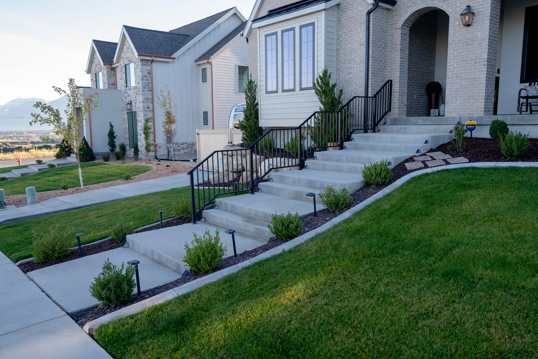 Front steps and sloped lawn by J&H Landscaping in Salem