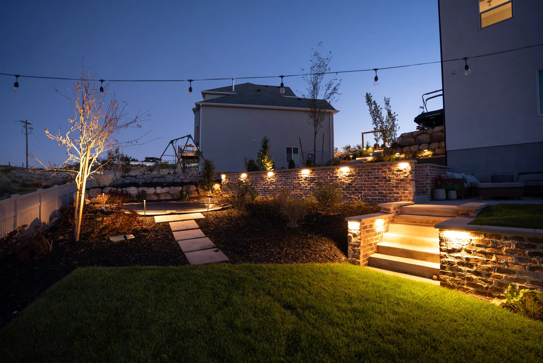 Lit steps and stone wall by J&H Landscaping in Saratoga Springs