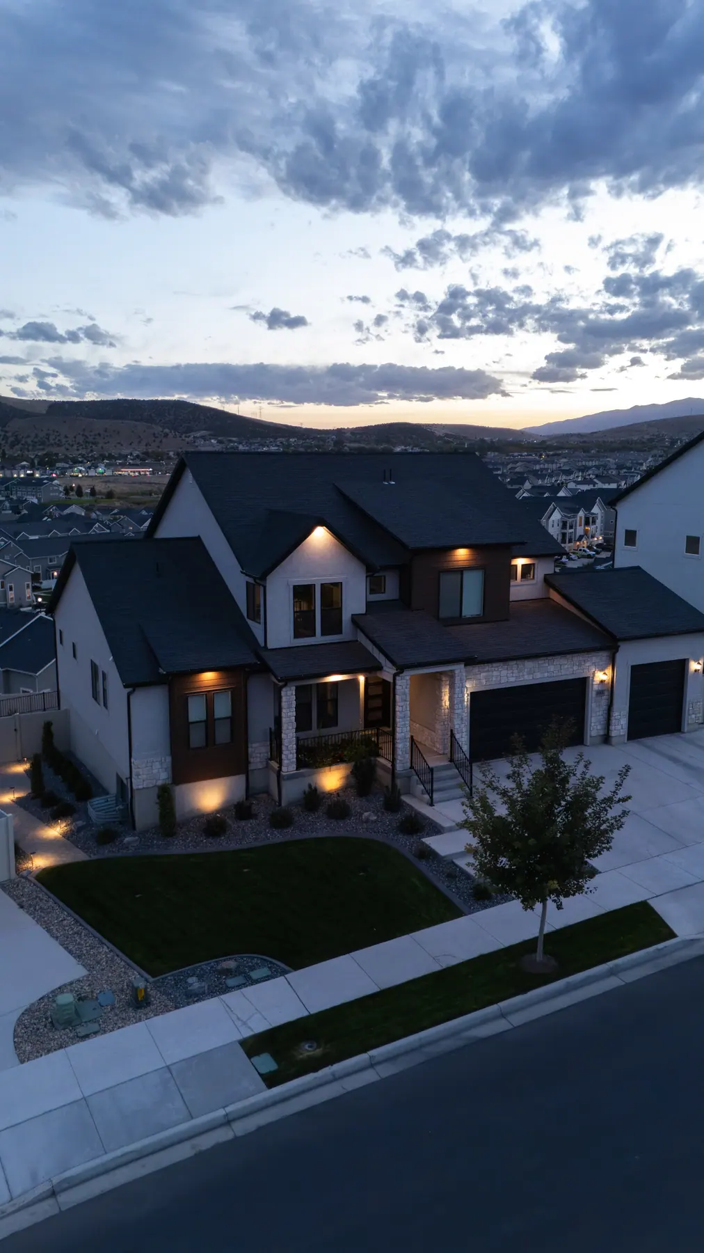 Lit front yard at dusk by J&H Landscaping in Saratoga Springs