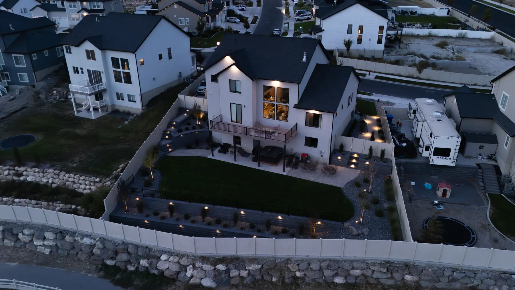 Terraced backyard at night by J&H Landscaping in Saratoga Springs