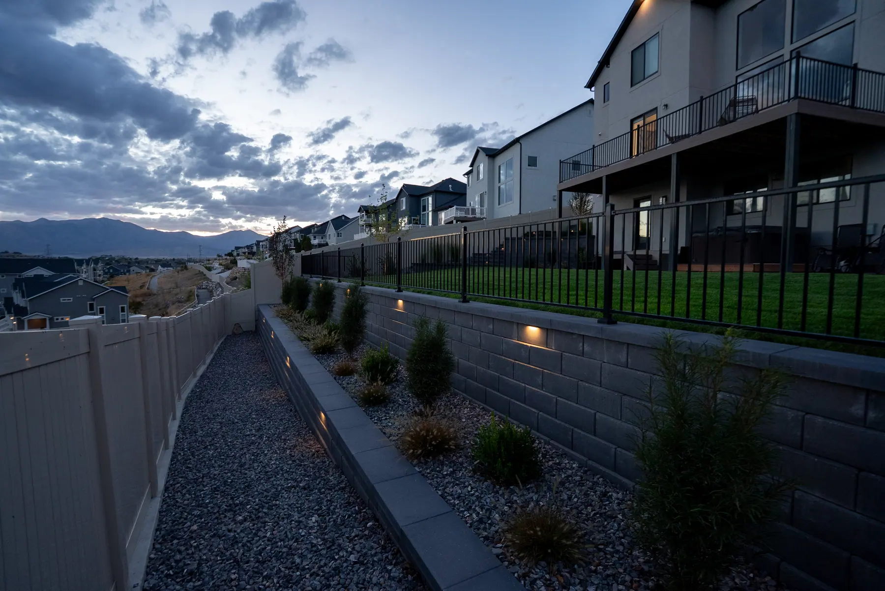Side yard path and wall lights by J&H Landscaping in Saratoga Springs
