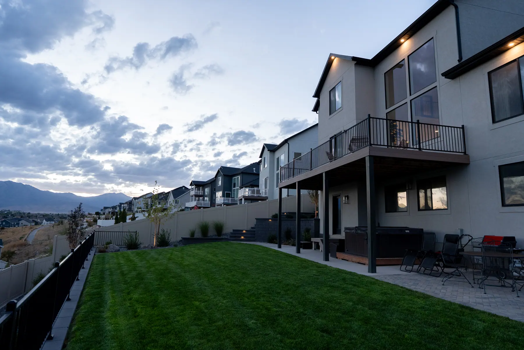 Backyard lawn and deck by J&H Landscaping in Saratoga Springs
