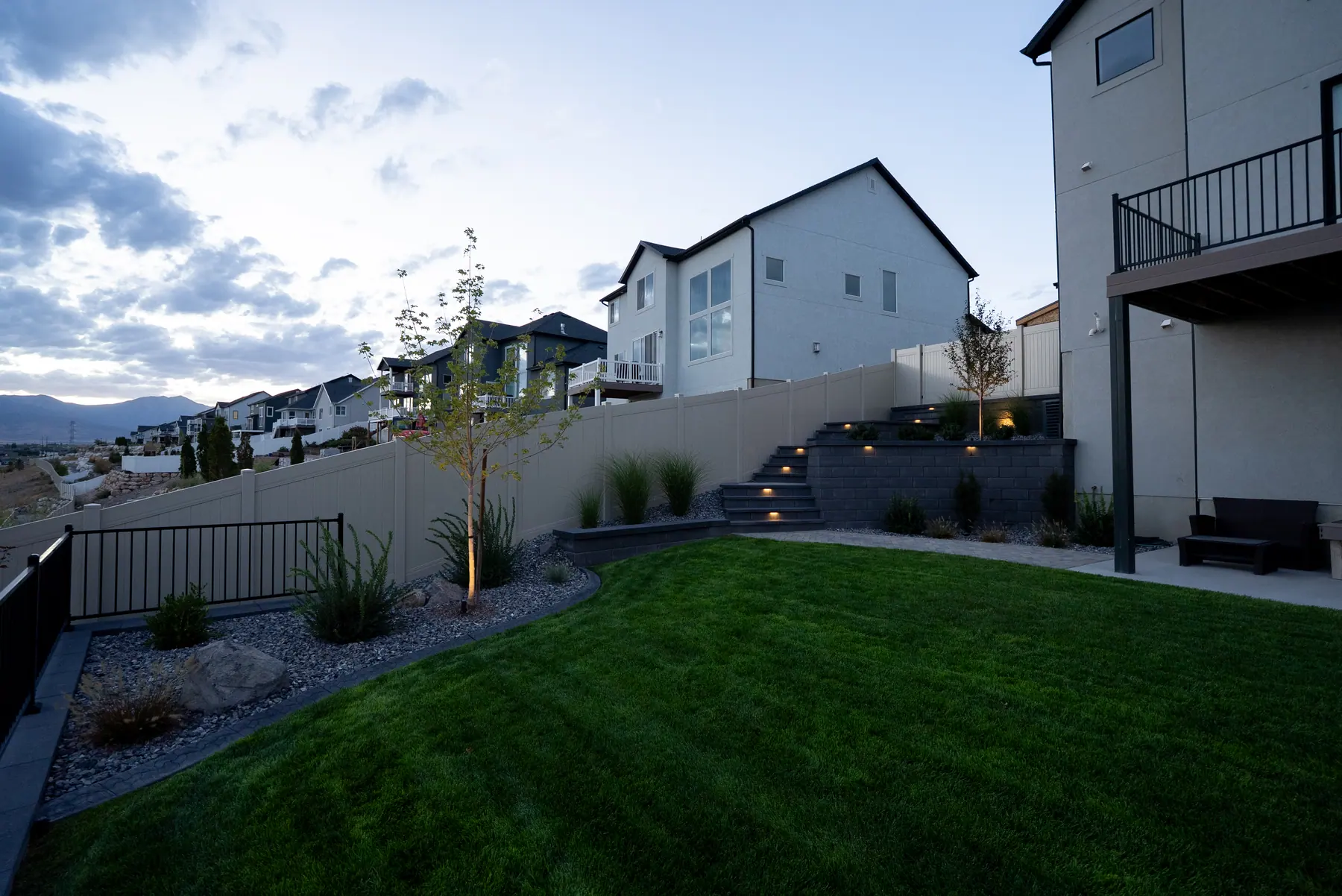 Backyard lawn and wall steps by J&H Landscaping in Saratoga Springs