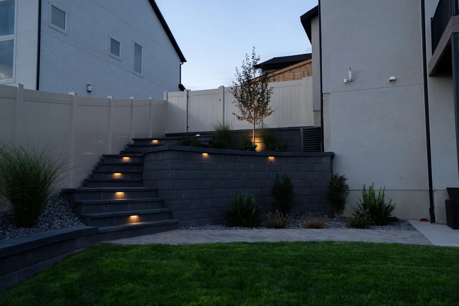 Terraced steps with wall lights by J&H Landscaping in Saratoga Springs