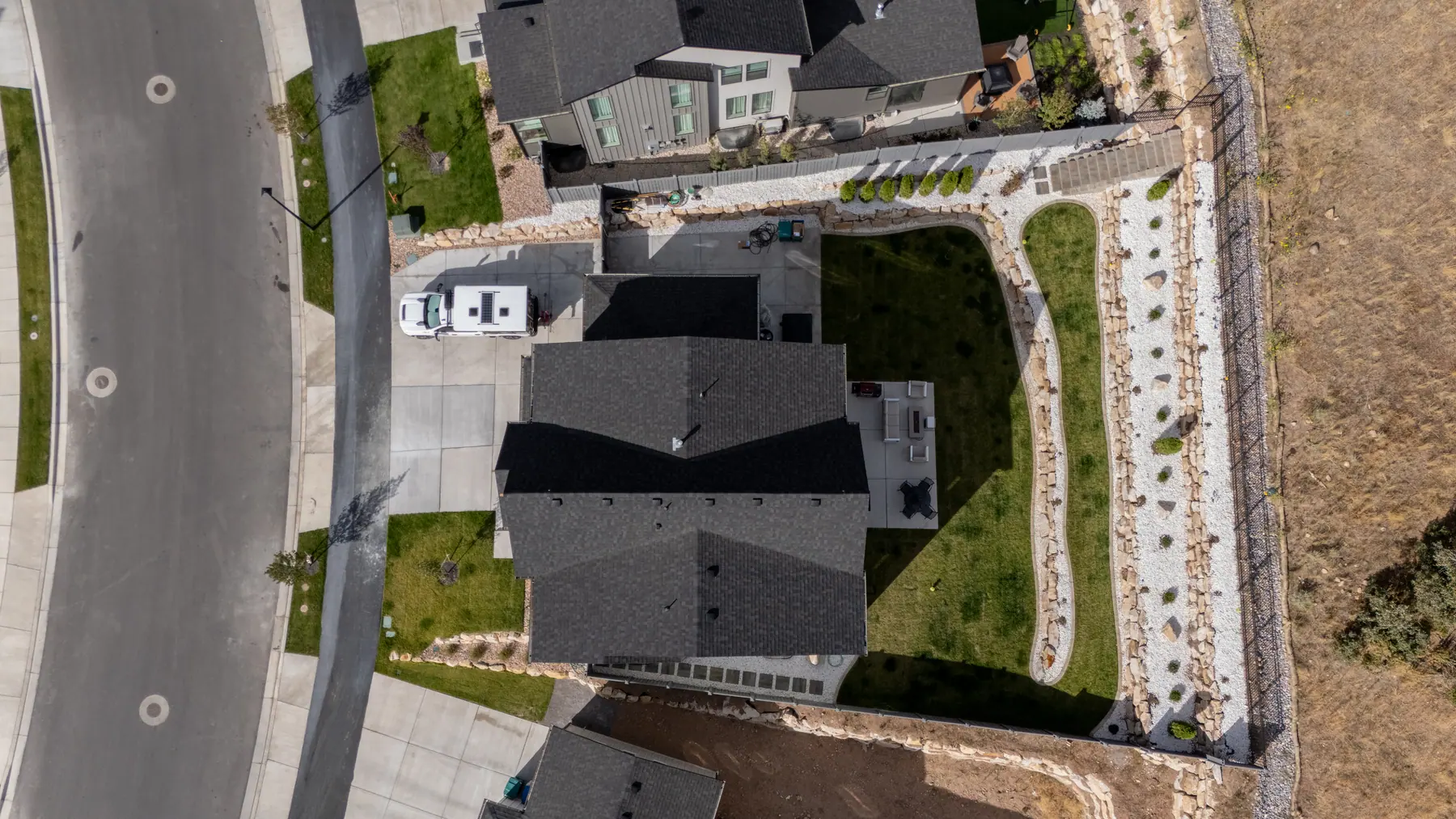 Backyard below a hillside by J&H Landscaping in Lehi