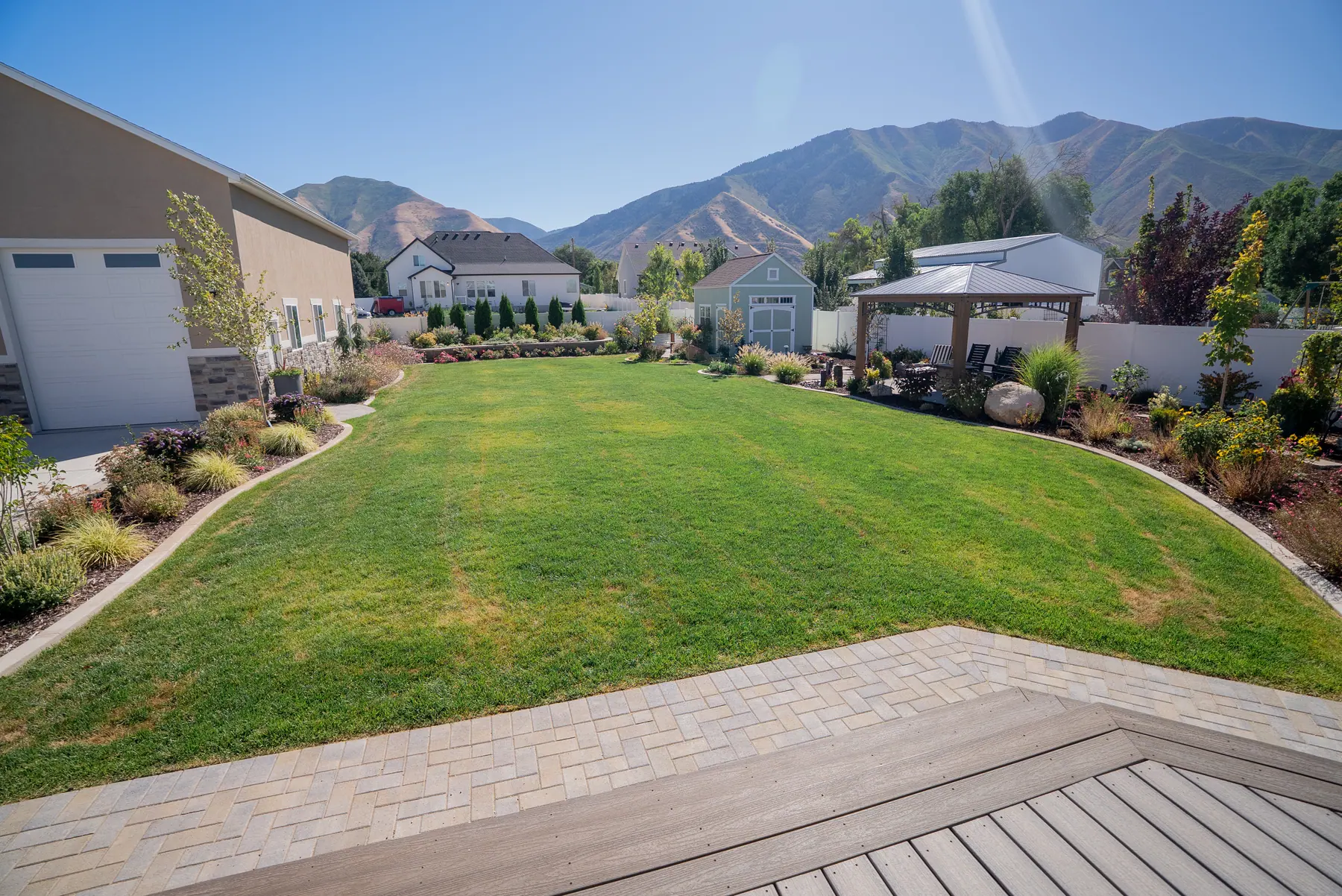Backyard lawn with mountain views by J&H Landscaping in Mapleton