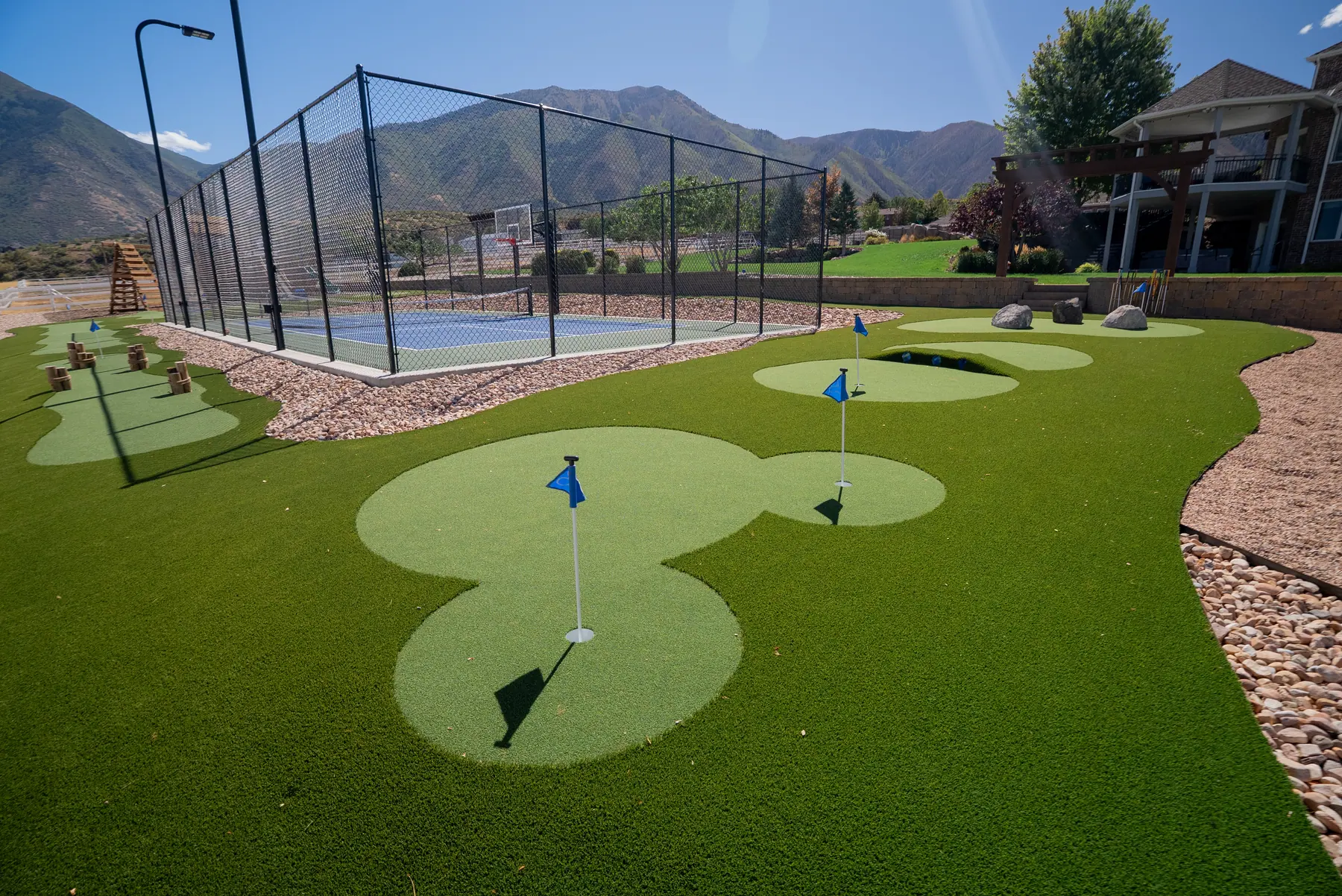 Putting green beside the court by J&H Landscaping in Elk Ridge