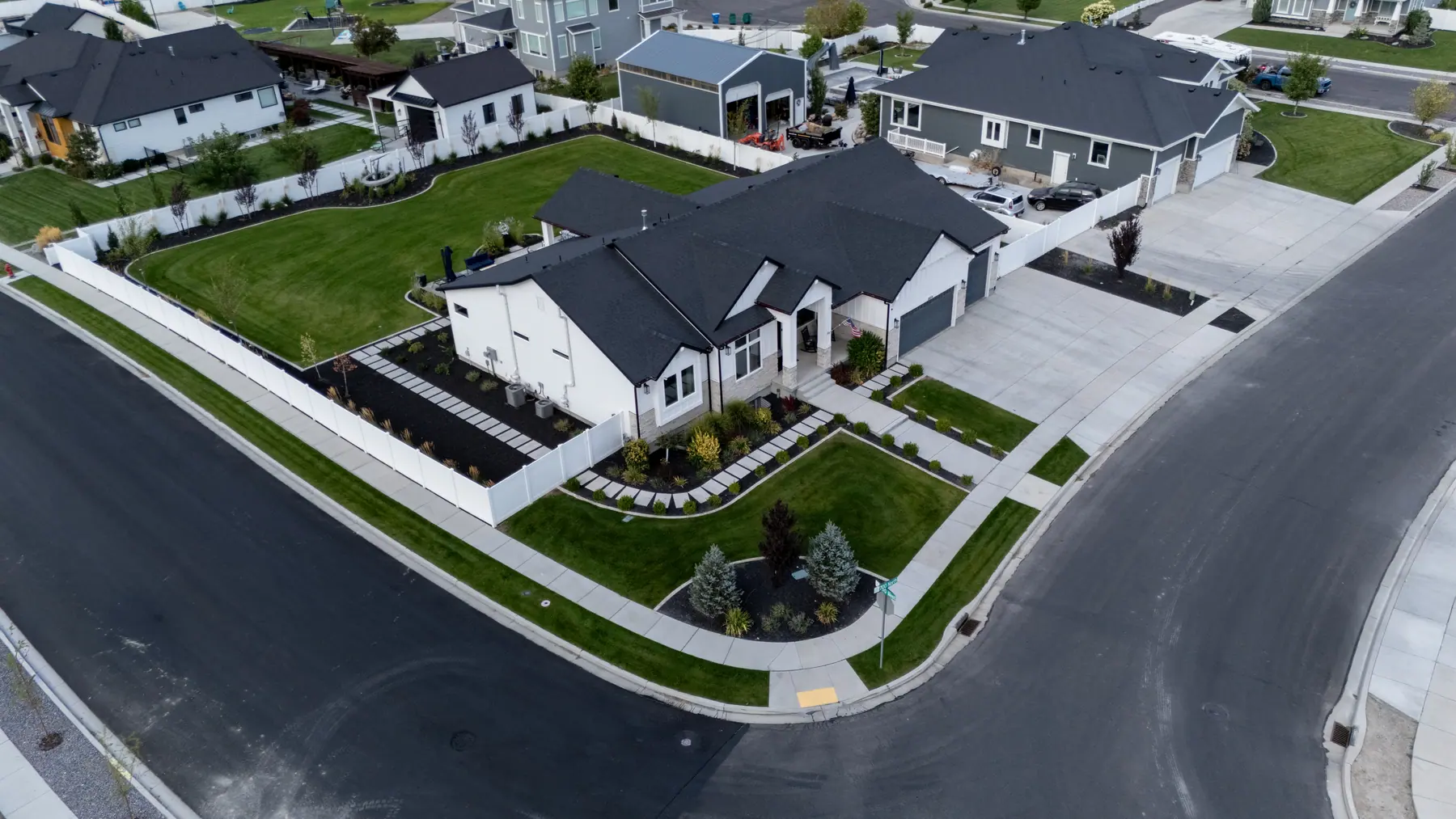 Corner lot with fresh lawn by J&H Landscaping in Utah County