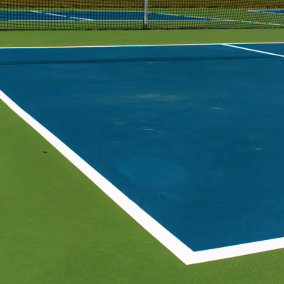 Pickleball court surface with smooth blue and green areas, featuring clean white striping, emphasizing quality construction for durability in Payson, Utah.