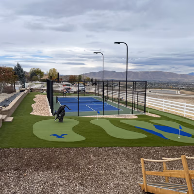 Pickleball court and putting green in Payson, Utah, showcasing durable surfaces, landscaped surroundings, and views of the mountains, reflecting J&H Landscaping's commitment to quality sports court construction.